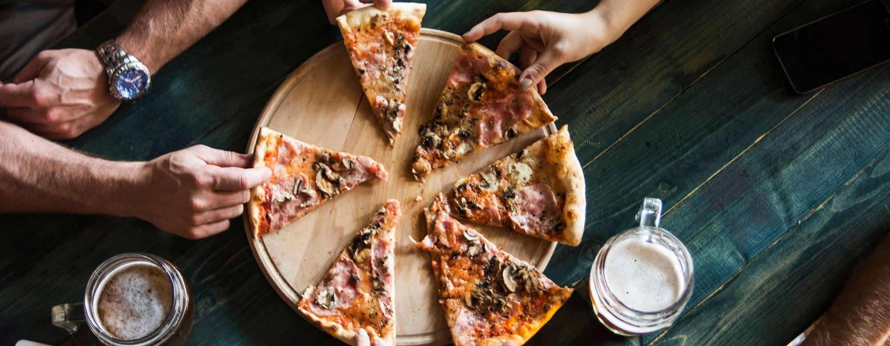 a group of people eating pizza